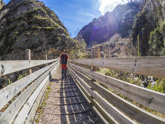 Spain, Asturia, Cantabrian Mountains, senior man on a hiking trip crossing a bridge - LAF02310