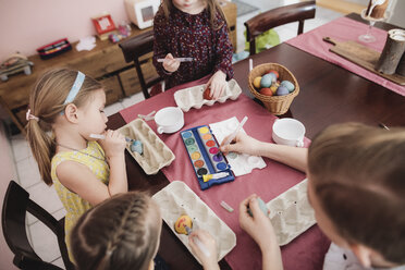 Kinder bemalen Ostereier auf dem Tisch zu Hause - KMKF00926