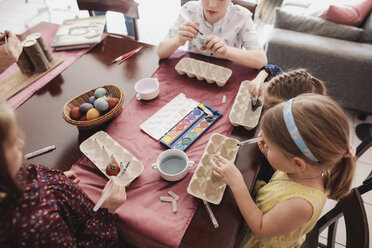 Kinder bemalen Ostereier auf dem Tisch zu Hause - KMKF00927