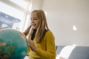 Mädchen zu Hause mit Blick auf den Globus - KNSF05828