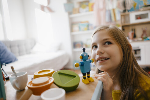 Girl at home playing with toy robot - KNSF05839