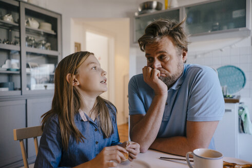 Daughter talking to father in kitchen at home - KNSF05851