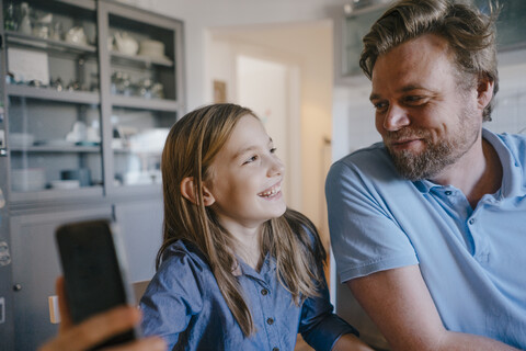 Glücklicher Vater und Tochter machen ein Selfie zu Hause, lizenzfreies Stockfoto