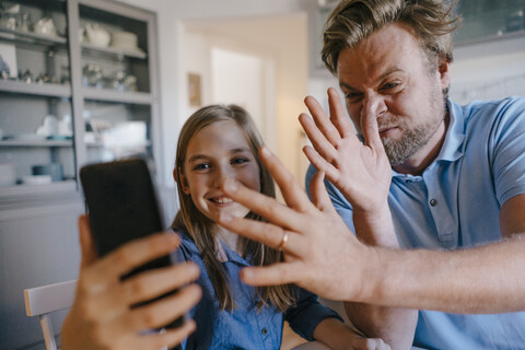 Verspielter Vater und Tochter machen ein Selfie zu Hause, lizenzfreies Stockfoto