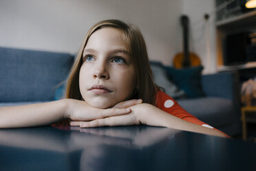 Serious girl resting her head on coffee table at home - KNSF05879