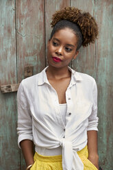 Portrait of woman with red lips standing in front of wooden door - VEGF00152