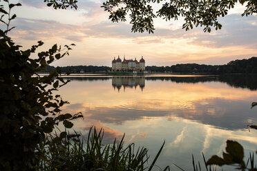 Germany, Saxony, Moritzburg Castle at castle pond in the evening - ASCF01010