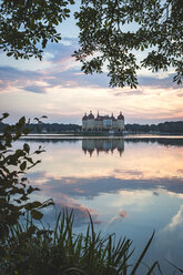 Germany, Saxony, Moritzburg Castle at castle pond in the evening - ASCF01011