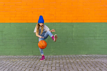 Young girl playing basketball, dribbling and lifting leg - ERRF01230