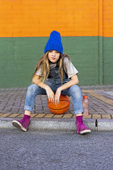 Young girl sitting on basketball - ERRF01244