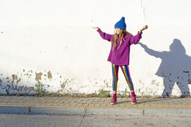 Girl wearing colorful clothing in front of a white wall - ERRF01270