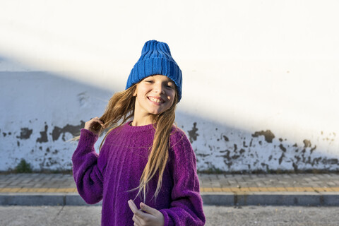 Portrait of young girl wearing blue woolly hat stock photo