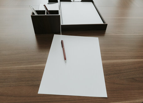 Ballpen and paper on wooden desk in office - AHSF00307