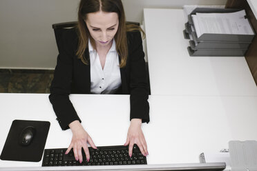 Junge Frau arbeitet an der Rezeption im Büro - AHSF00318