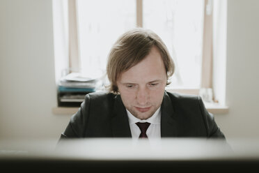 Geschäftsmann mit Computer am Schreibtisch im Büro - AHSF00324