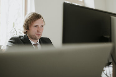 Geschäftsmann mit Computer am Schreibtisch im Büro - AHSF00325