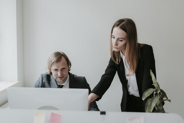 Businessman and woman working together at desk in office - AHSF00342