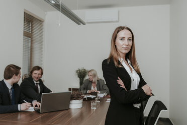 Porträt einer selbstbewussten jungen Geschäftsfrau bei einem Treffen im Konferenzraum - AHSF00348