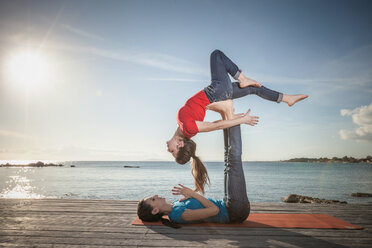 Frauen üben Acro-Yoga am Meer - CUF50661
