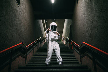 Astronaut gestikuliert auf einer Treppe - CUF50670