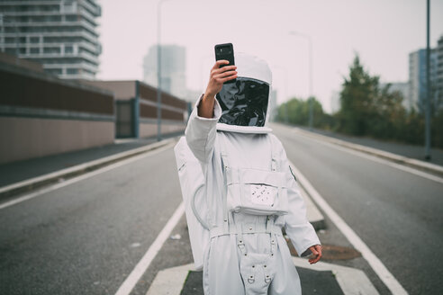 Astronaut taking selfie in middle of road - CUF50698