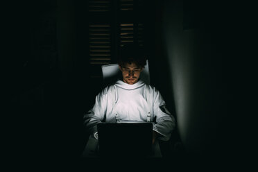 Astronaut mit Laptop im dunklen Raum - CUF50699