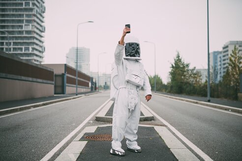 Astronaut taking selfie in middle of road - CUF50703