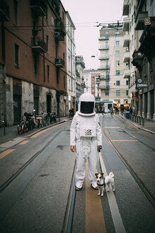Astronaut and pet dog in middle of street - CUF50704