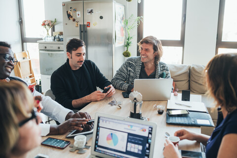 Geschäftsleute und Geschäftsfrauen diskutieren im Loftbüro, lizenzfreies Stockfoto