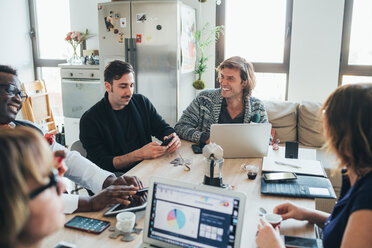 Businessmen and businesswomen having discussion in loft office - CUF50730