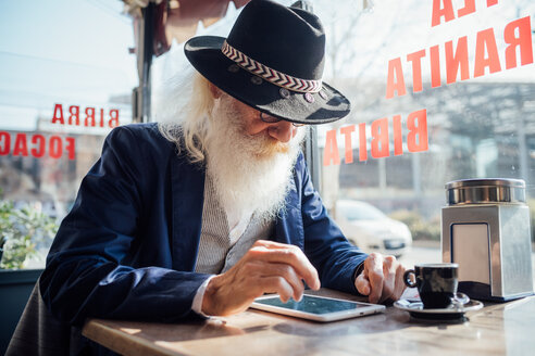 Älterer Geschäftsmann mit digitalem Tablet in einem Café, Mailand, Lombardei, Italien - CUF50731