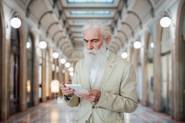 Senior businessman using digital tablet inside office building, Milano, Lombardia, Italy - CUF50755