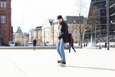 Mann auf dem Skateboard auf einem Stadtplatz, Freiburg, Baden-Württemberg, Deutschland - CUF50837