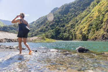 Frau beim Überqueren eines Baches, Pagudpud, Ilocos Norte, Philippinen - CUF50874