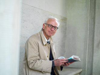 Älterer Mann im Regenmantel liest Zeitung, Porträt, Kopenhagen, Hovedstaden, Dänemark - CUF50910