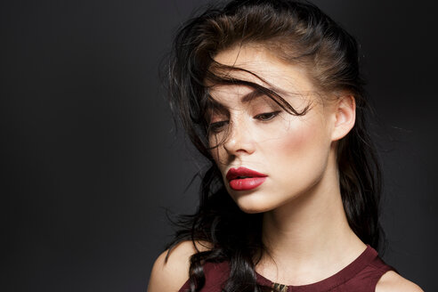 Schöne junge Frau mit langem schwarzem fliegendem Haar, Studioporträt - CUF50940