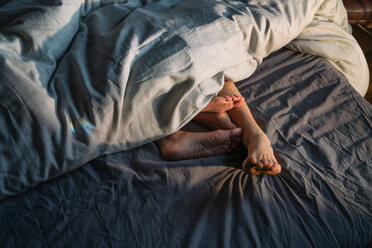 Füße eines Paares ragen unter der Bettdecke hervor - CUF50993