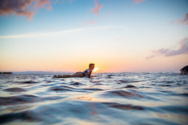 Surfer gleitet im Meer bei Sonnenuntergang, Pagudpud, Ilocos Norte, Philippinen - CUF51032