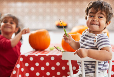 Children carving pumpkin in kitchen - CUF51084