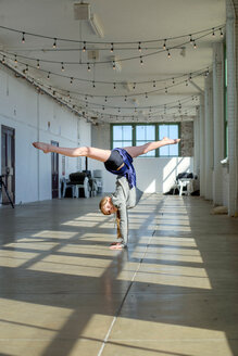 Teenager-Mädchen macht Handstand und Spagat im Tanzstudio - ISF21296