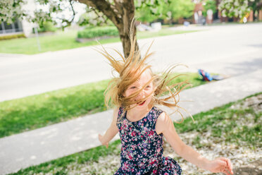 Girl with long blond hair dancing on suburban street - ISF21300