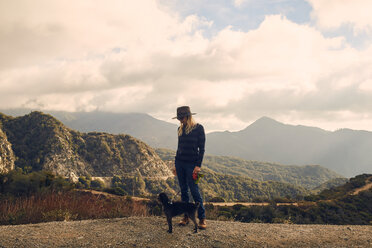 Woman walking dog on hilltop, Big Bear Lake, California, United States - ISF21335