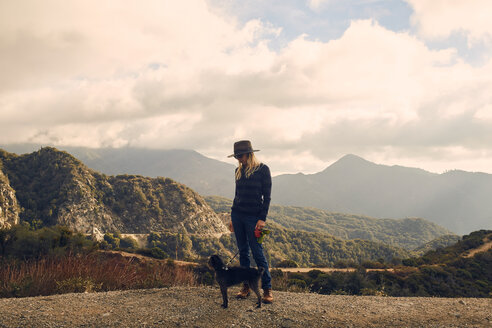 Frau geht mit Hund auf einer Bergkuppe spazieren, Big Bear Lake, Kalifornien, Vereinigte Staaten - ISF21335