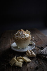 Tasse weißer Schokoladenpudding mit Sahne und Nüssen - ISF21361