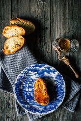 Slice of baguette with honey on plate - ISF21367