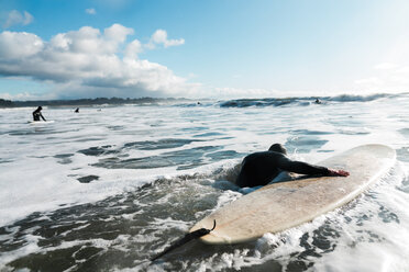 Junger männlicher Surfer mit Surfbrett im pazifischen Ozean, Rückansicht, Arcata, Kalifornien, Vereinigte Staaten - ISF21421