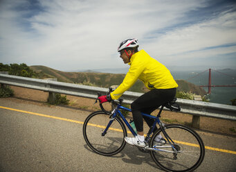 Hispanic man riding bicycle on waterfront road - BLEF03068