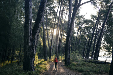 Caucasian woman standing on path in forest - BLEF03112