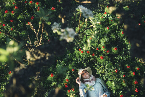Smiling Caucasian woman laying in flowers - BLEF03120