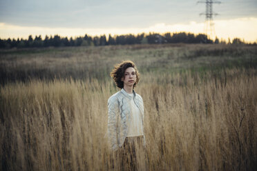 Kaukasische Frau steht in einem Feld mit hohem Gras - BLEF03121